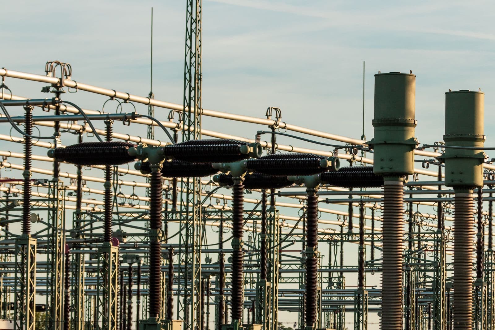 High voltage electrical substation with busbars, insulators and switchgear at dusk