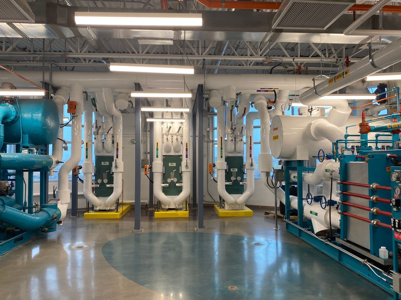 Chilled water plant room with pumps, heat exchangers and insulated pipework, the mechanical infrastructure Clear recruits engineers for